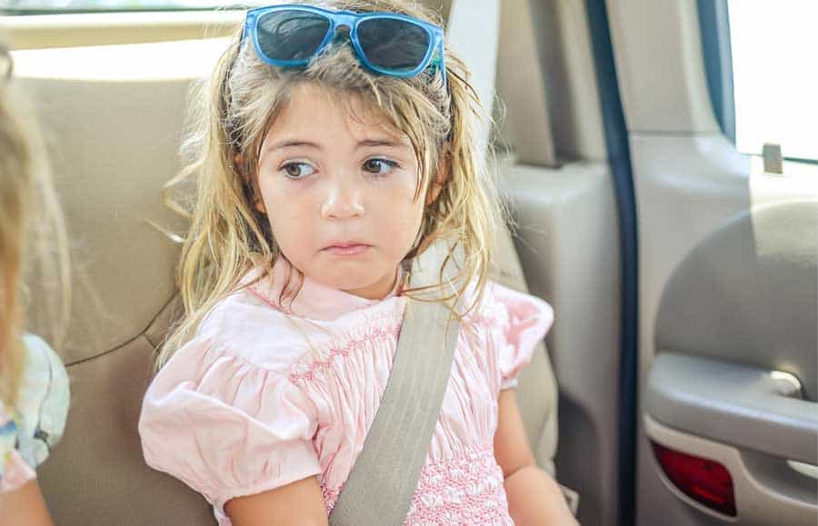 upset kid traveling in car