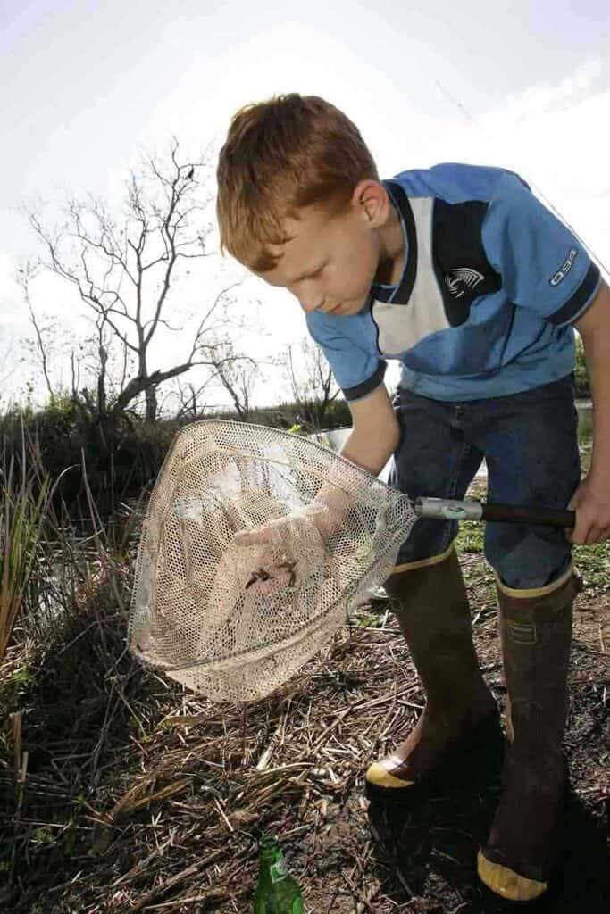 kid with fish in fishing net